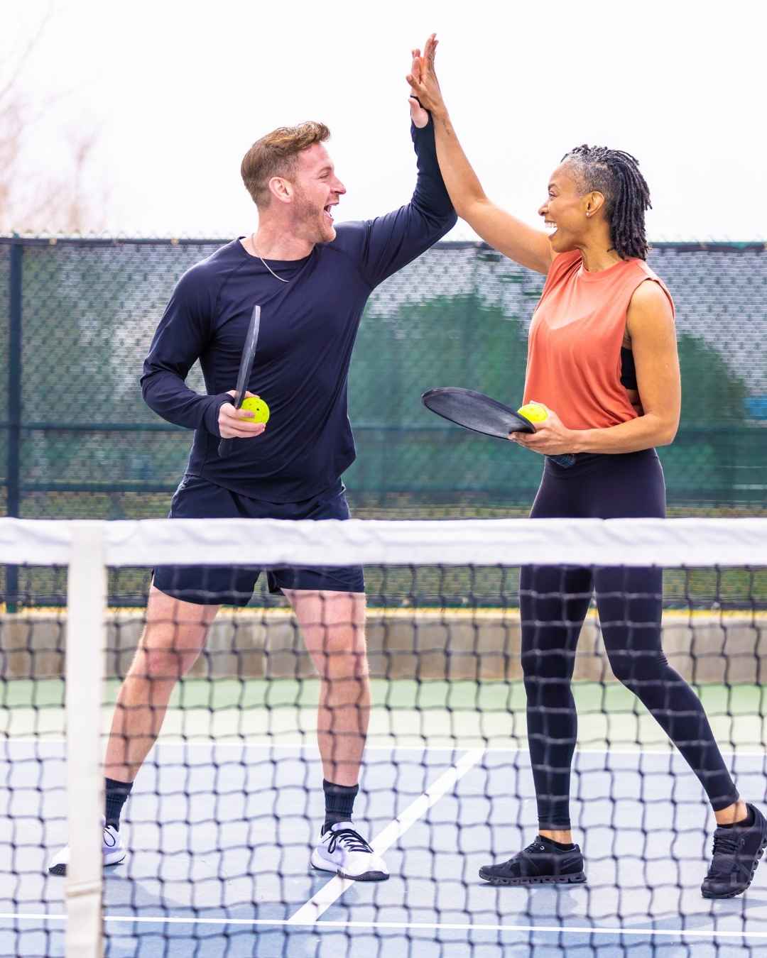 Home 2 Adultes souriants sur un terrain de pickleball