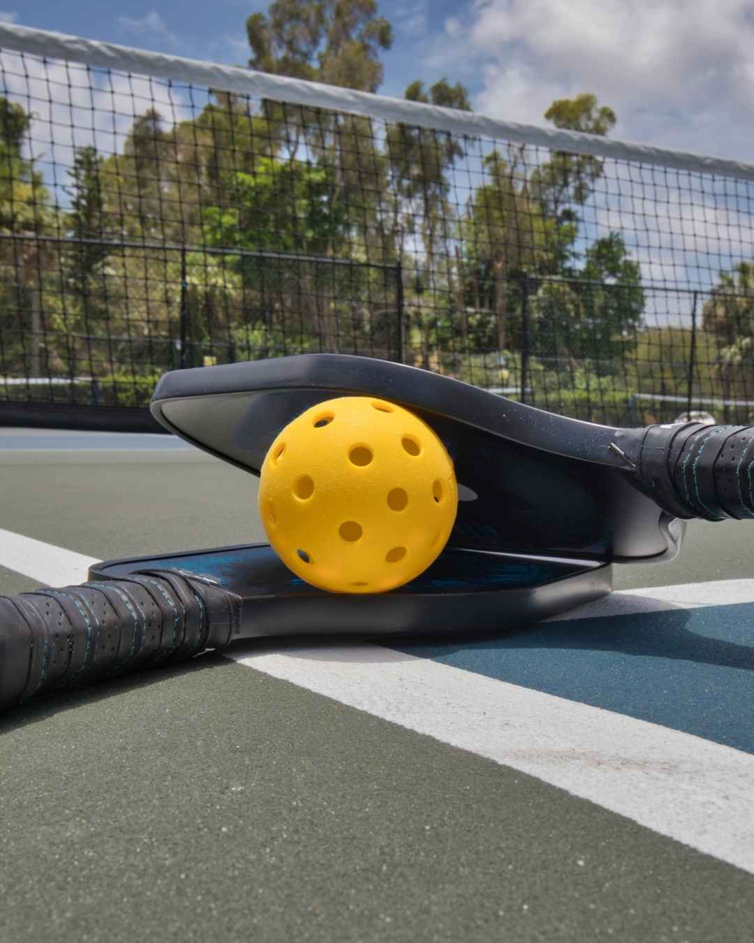Raquettes et balles de pickleball sur un terrain