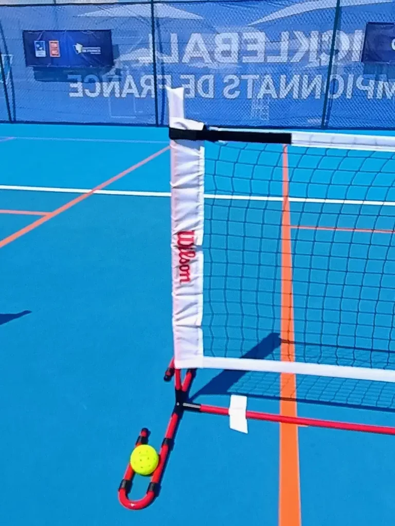 Filet de pickleball Wilson et balle jaune sur un court bleu des Championnats de France 2026