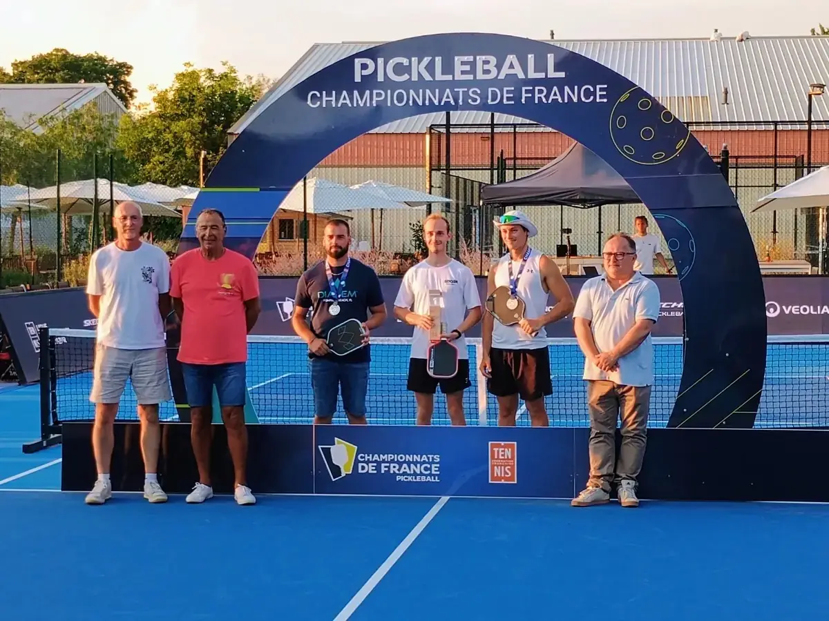 Podium de trois médaillés sous l'arche des Championnats de France de pickleball 2026