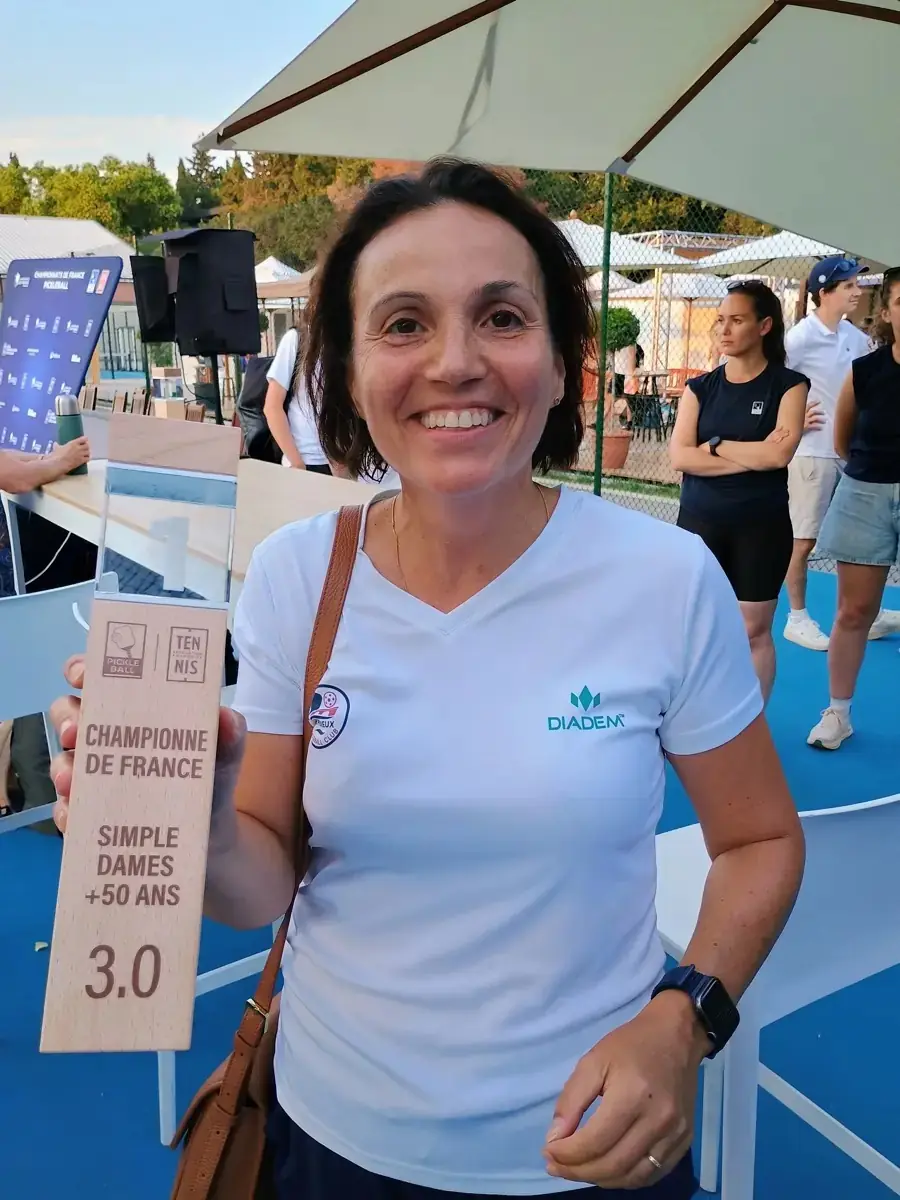 Caroline Stock, championne de France du simple dames 3.0 +50 ans, tenant sa plaque aux Championnats de France de pickleball 2026