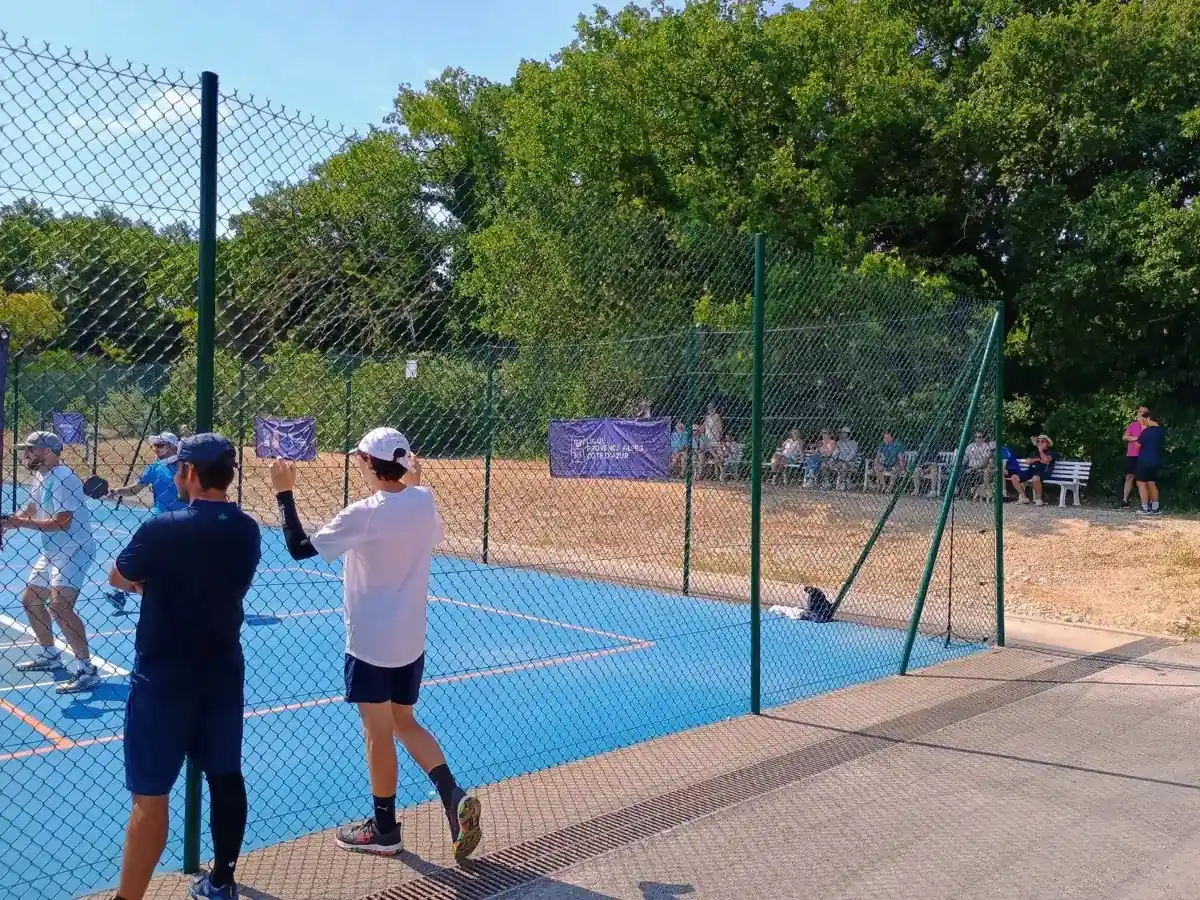 Spectateurs derrière le grillage autour des terrains extérieurs des Championnats de France de pickleball 2026