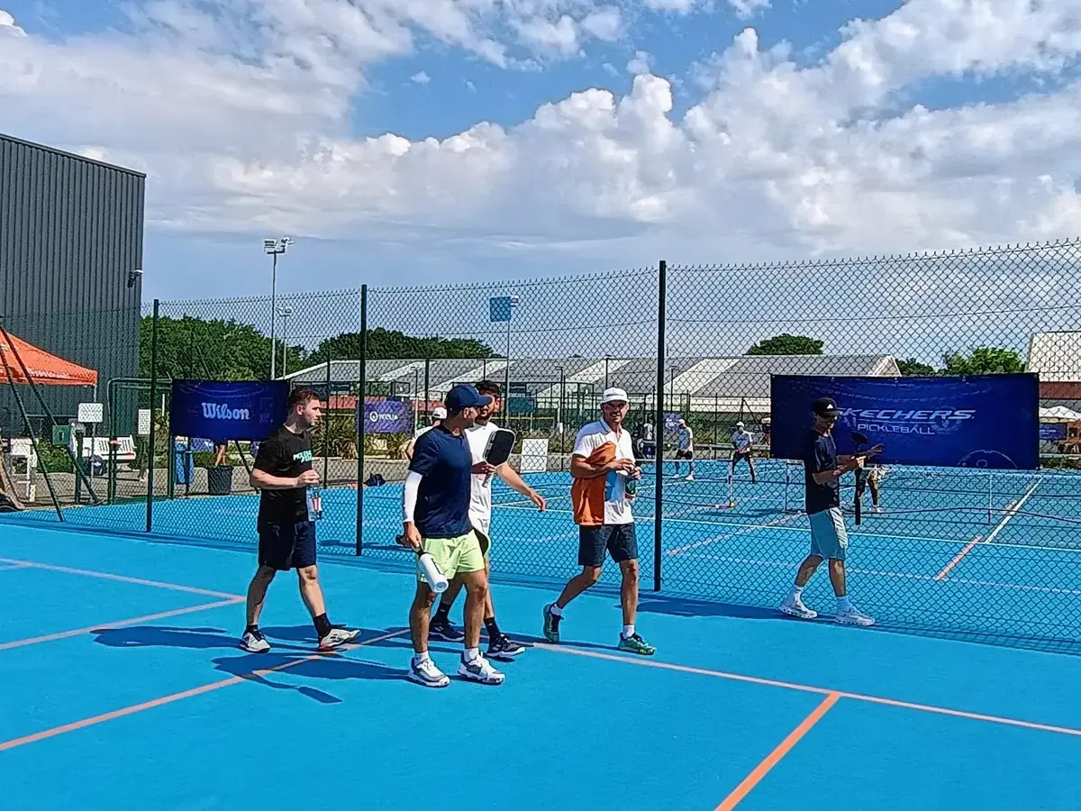 Quatre personnes près du filet sur un terrain extérieur des Championnats de France de pickleball 2026