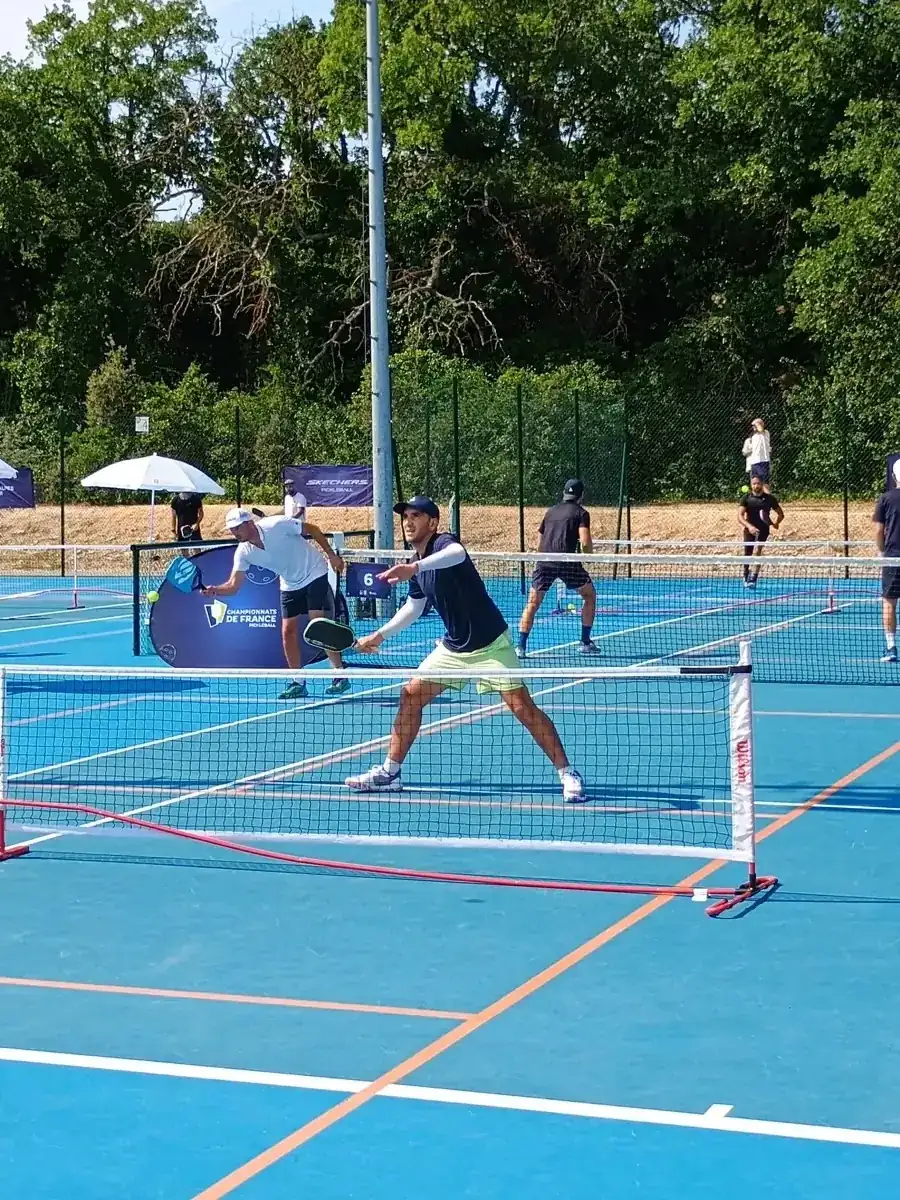 Joueurs au filet sur un terrain extérieur des Championnats de France de pickleball 2026 à Aix-en-Provence