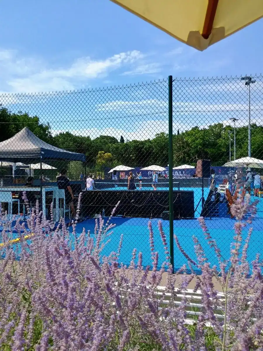 Terrain extérieur encadré par des fleurs violettes aux Championnats de France de pickleball 2026