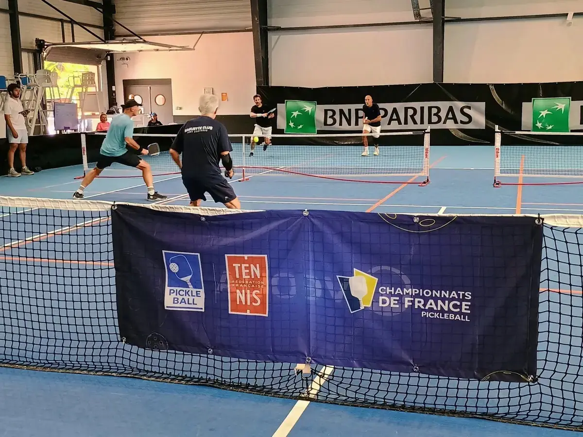 Banderole FFT et Championnats de France de pickleball 2026 accrochée au filet d’un terrain intérieur