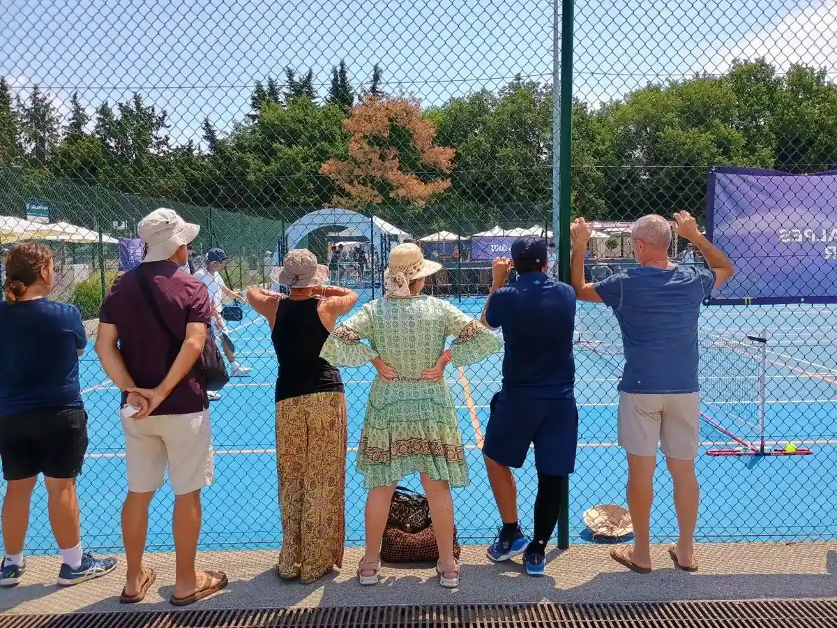 Spectateurs alignés derrière le grillage des terrains extérieurs des Championnats de France de pickleball 2026