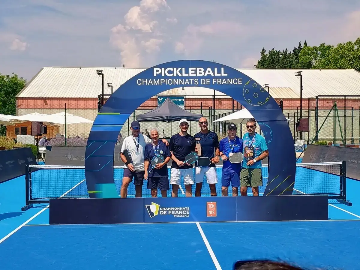 Groupe masculin sous l’arche officielle des Championnats de France de pickleball 2026