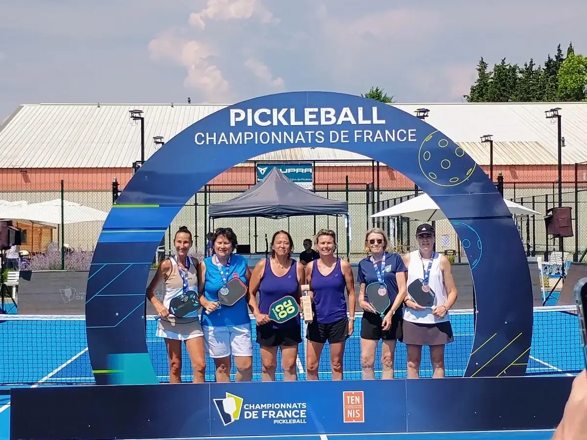 Groupe féminin sous l’arche officielle des Championnats de France de pickleball 2026