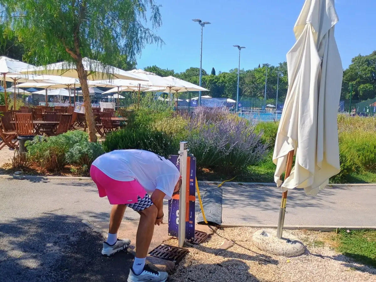 Participant penché près des parasols sur le site extérieur des Championnats de France de pickleball 2026