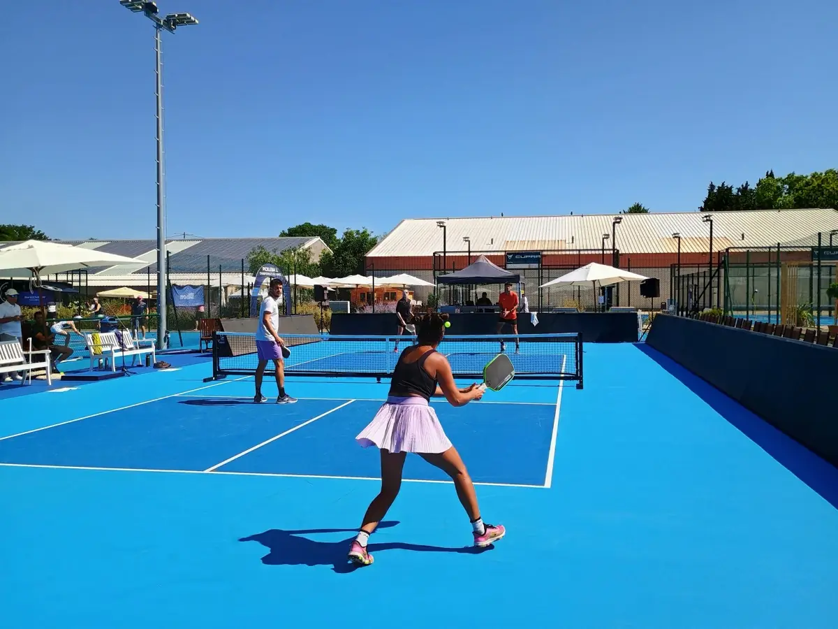 Joueuse en fond de court sur un terrain extérieur pendant la troisième journée des Championnats de France de pickleball 2026