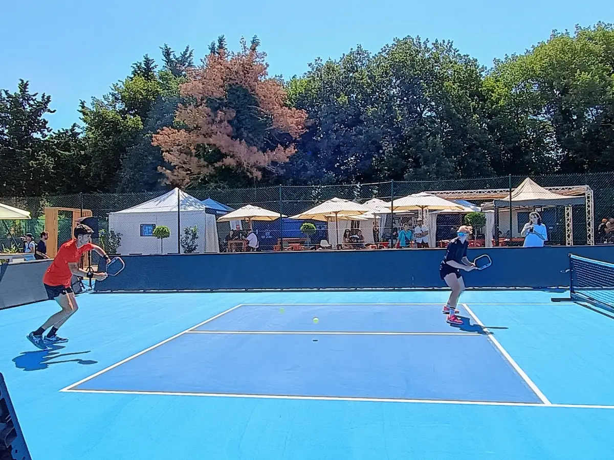 Vue large d'un terrain extérieur en jeu aux Championnats de France de pickleball 2026