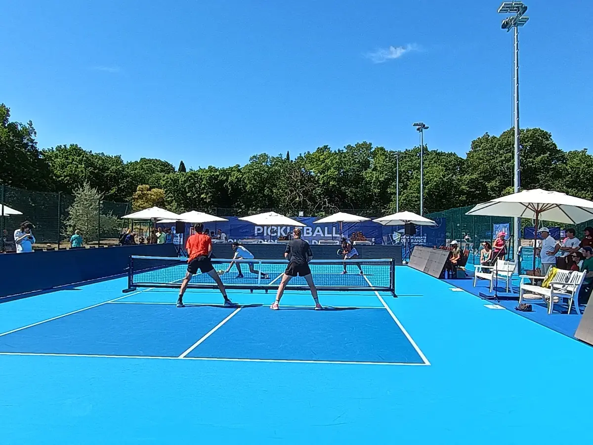 Duel en double sur un terrain bleu pendant la troisième journée des Championnats de France de pickleball 2026