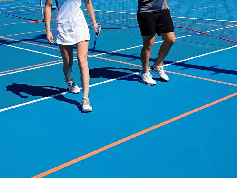 Détail des appuis sur le revêtement bleu d'un terrain de pickleball en compétition