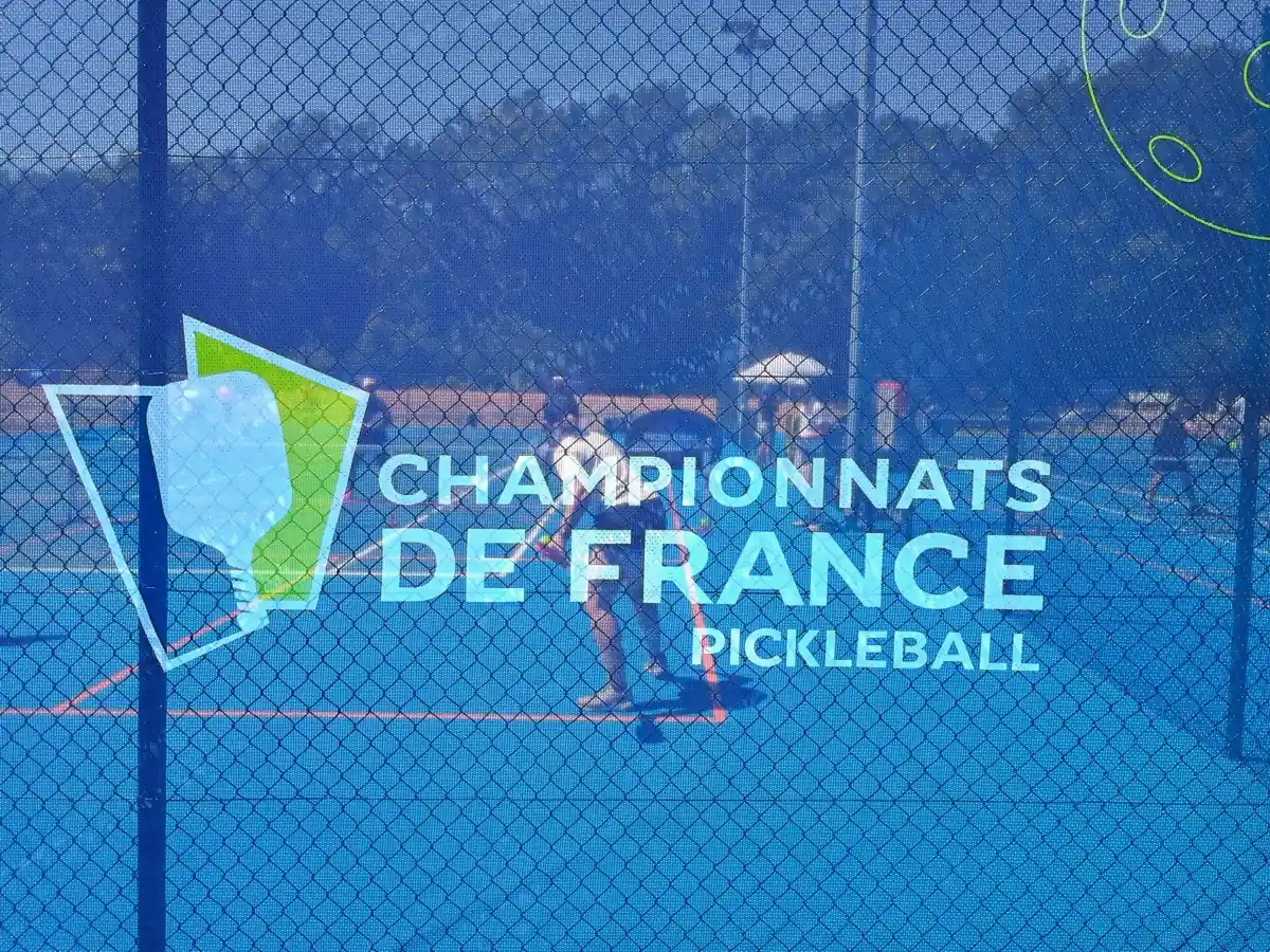 Filet et signalétique des Championnats de France de pickleball 2026 vus à travers le grillage