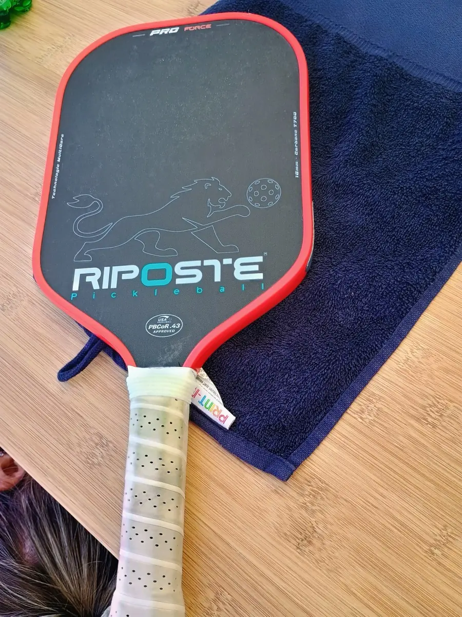Raquette Riposte posée sur un banc à proximité des terrains pendant les Championnats de France de pickleball 2026