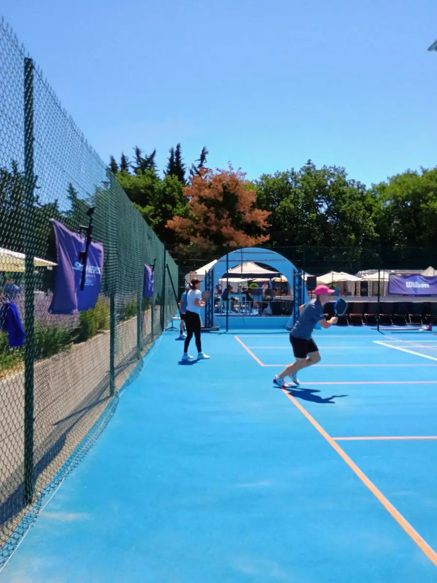 Allée bleue menant vers l'arche officielle et les terrains extérieurs des Championnats de France de pickleball 2026
