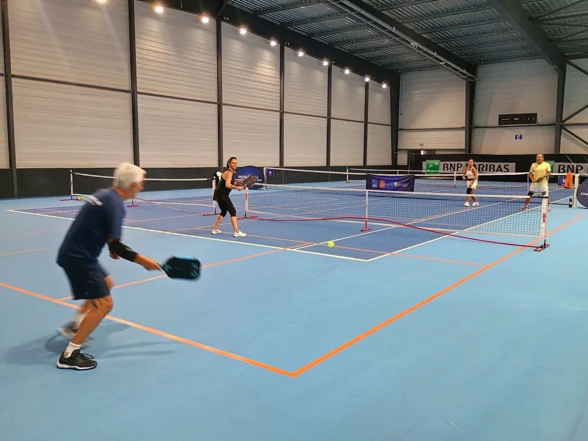 Joueur prêt à frapper sur un terrain intérieur pendant la troisième journée des Championnats de France de pickleball 2026