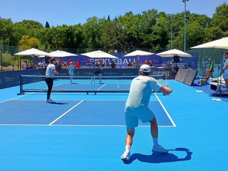 Joueur au service sur un terrain extérieur pendant la troisième journée des Championnats de France de pickleball 2026
