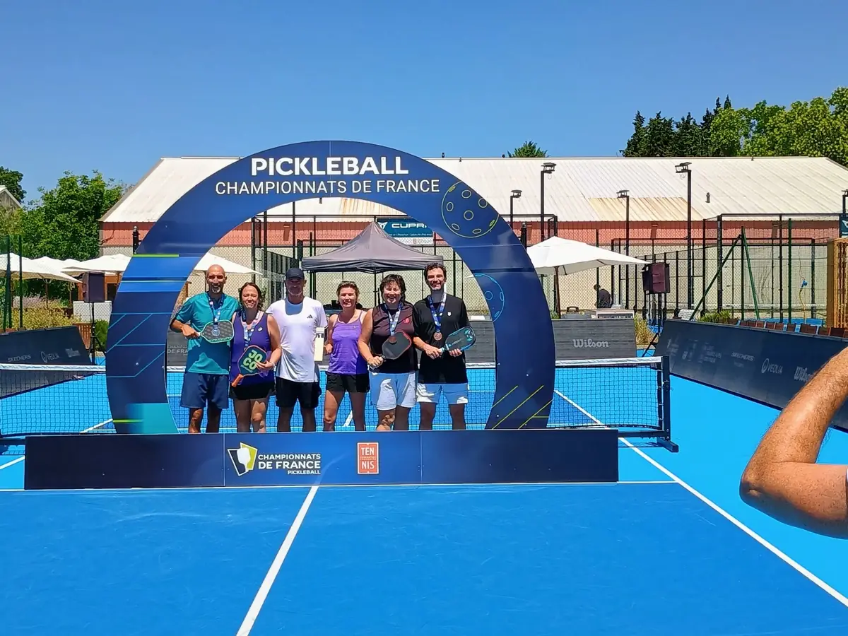 Groupe vu à distance sous l'arche des Championnats de France de pickleball 2026
