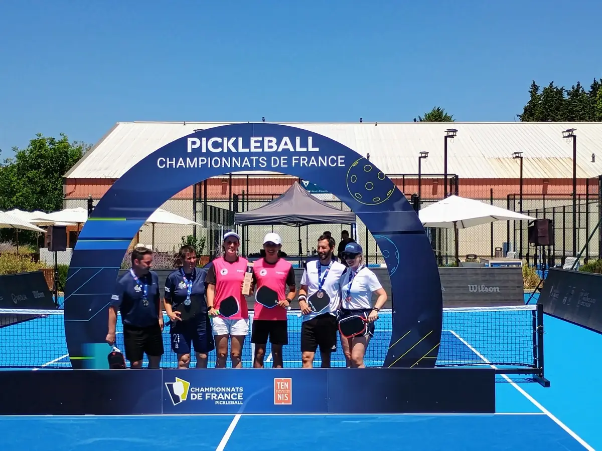 Équipe féminine réunie sous l'arche des Championnats de France de pickleball 2026