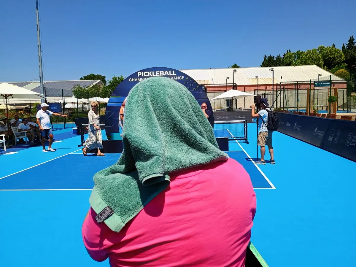 Personne de dos photographiant l'arche officielle des Championnats de France de pickleball 2026